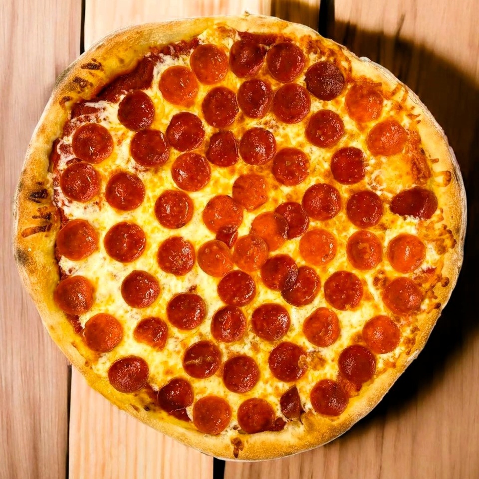 A whole pepperoni pizza from Hatcher Pass Pizza, with a golden crust, on a wooden surface.